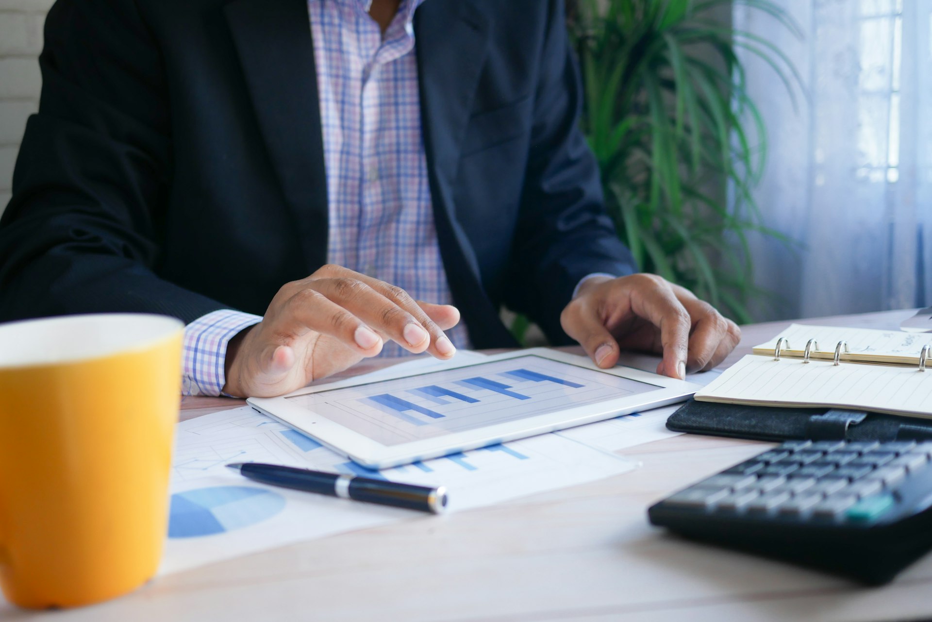 Financial analyst reviewing charts and reports on a tablet