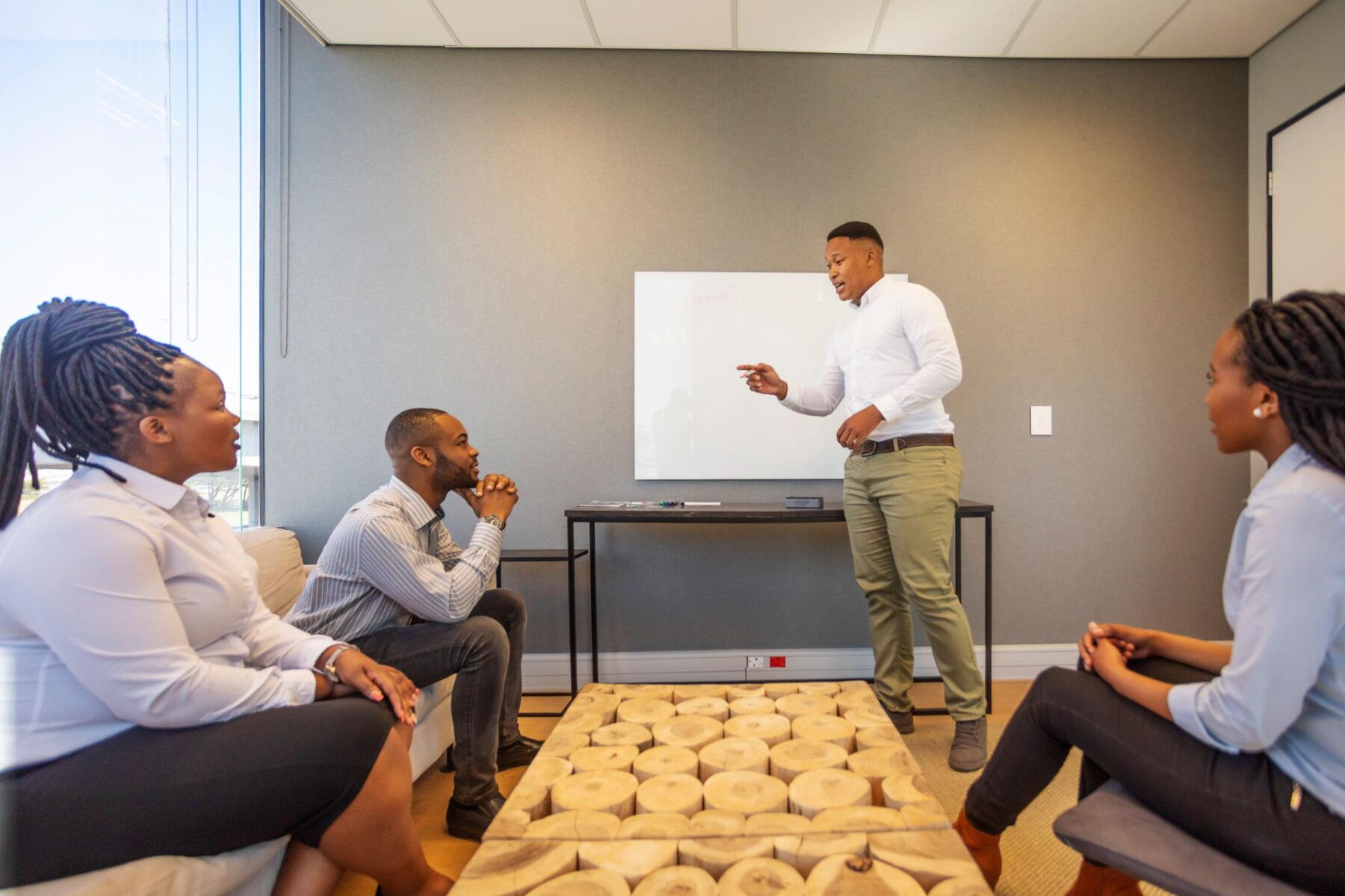 IFC facilitator leading a financial literacy training session at a whiteboard